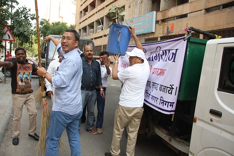 श्री पी.सी.पंकज नई दिल्ली में स्वच्छ भारत अभियान के दौरान कचरे के बिन में उगते हुए हैं।